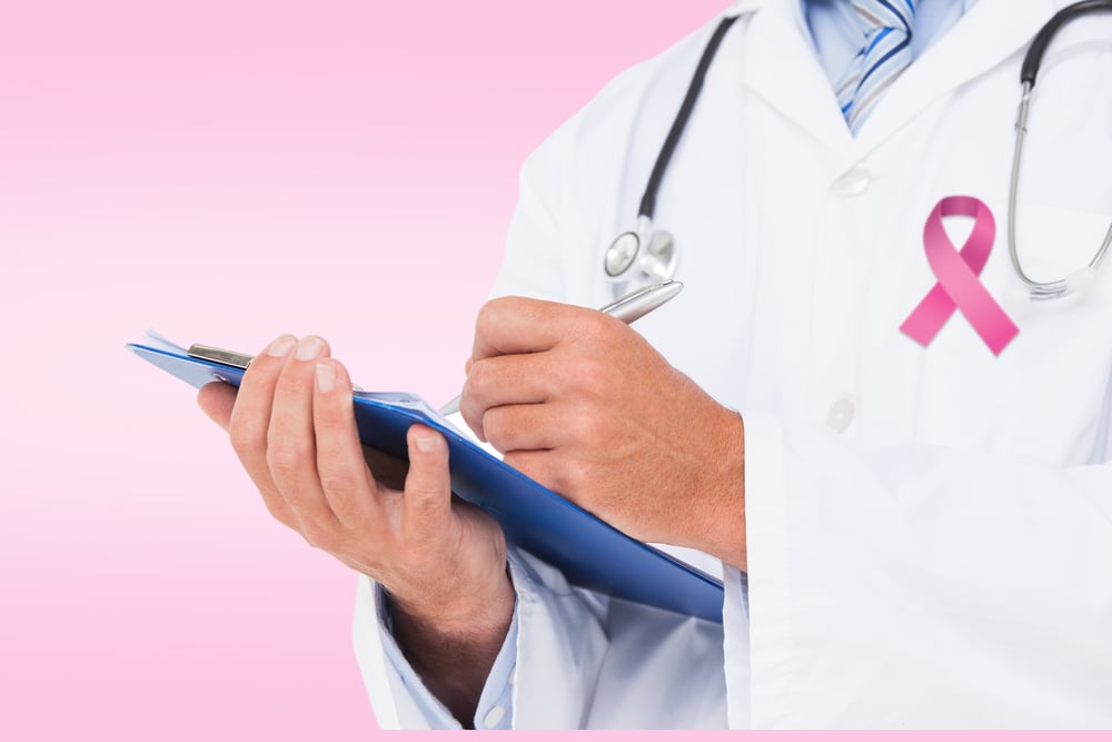 Doctor writing on clipboard against pink Doctor writing on clipboard against pink